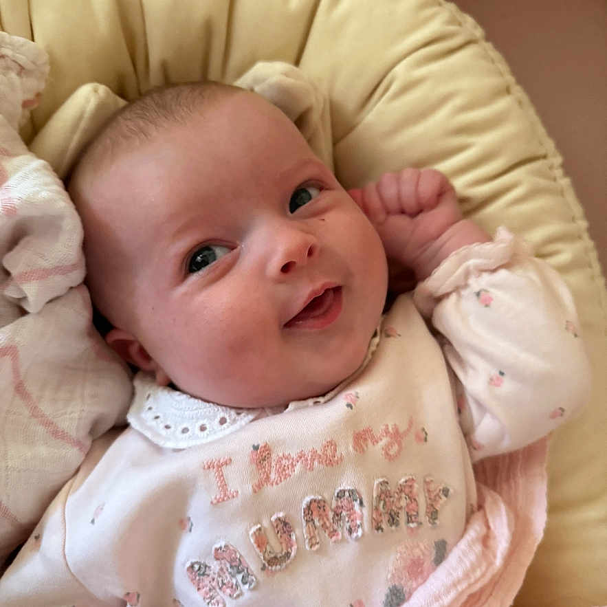 Bonnie Rose is registered to the contest to win money with this photo: baby, baby_girl, blanket, child, closeup, clothing, cozy, cushion, cute, face, happy, indoors, infant, newborn, person, pink, portrait, sleeping_bag, smiling, soft