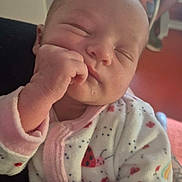 Wendy participe au concours pour gagner de l'argent avec cette photo : baby, sleeping, pajamas, hand, face, infant, person, closeup, tattoo, adult, blurred_background, cozy, cute, child, newborn, skin, indoors, resting, peaceful, soft