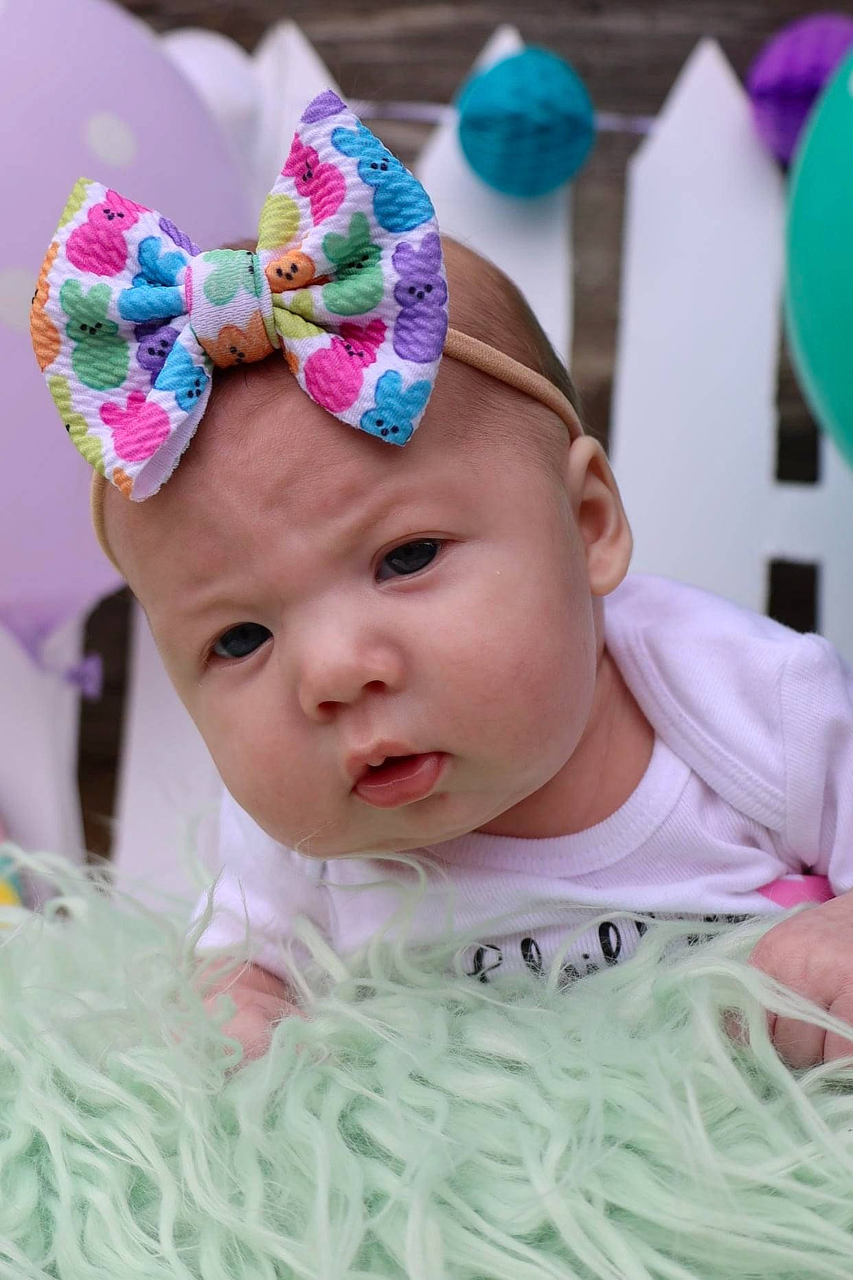 Finley is registered to the contest to win money with this photo: baby, baby_toddler_clothing, cap, cheek, eye, face, fun, green, happy, hat, head, headpiece, headwear, iris, person, petal, pink, skin, sun_hat, textile