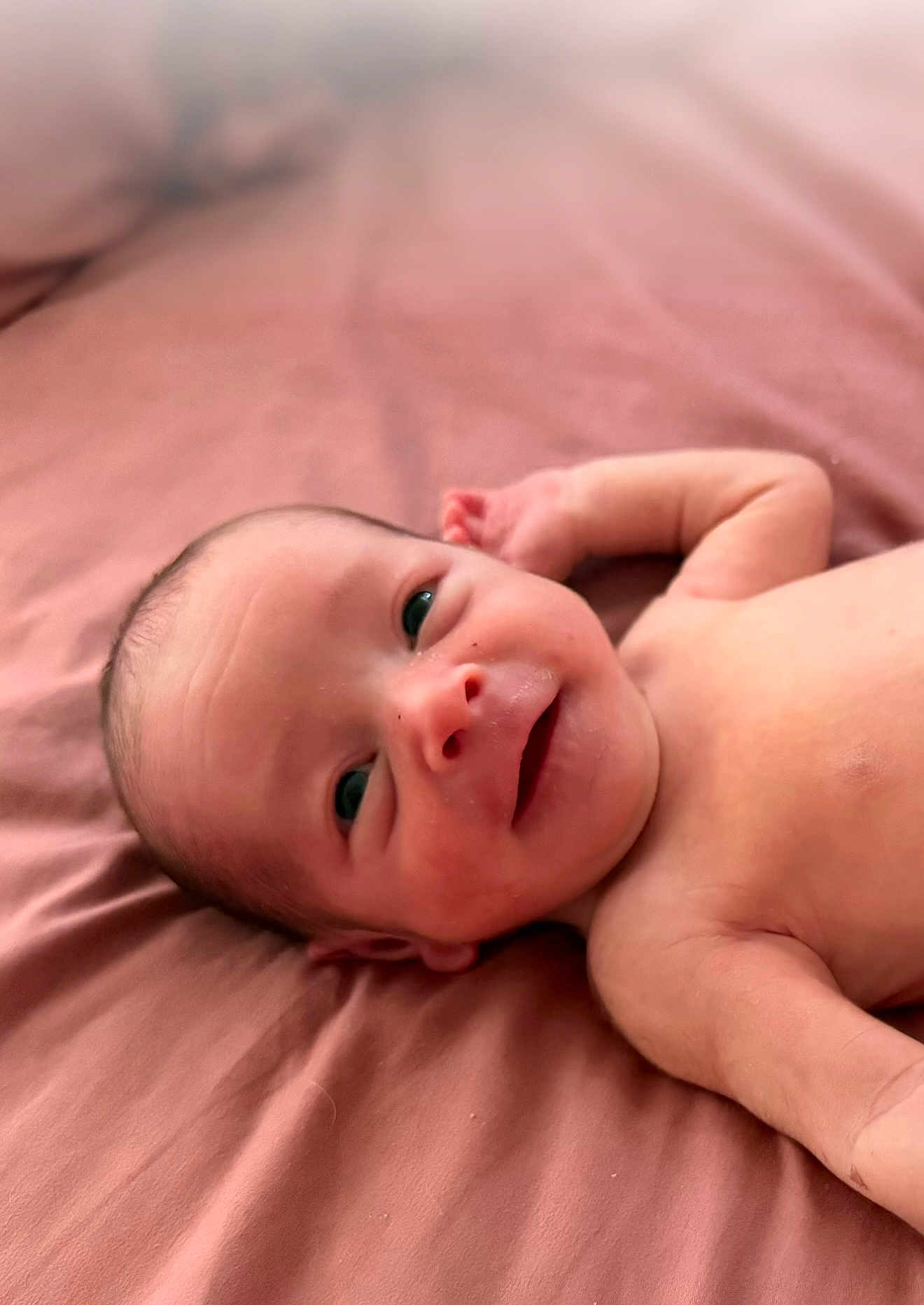 Crue joined the competition — help win amazing prizes! baby, newborn, infant, smiling, lying_down, pink_sheet, skin, face, eyes, hand, cute, portrait, bed, child, young, head, expression, resting, person, happy