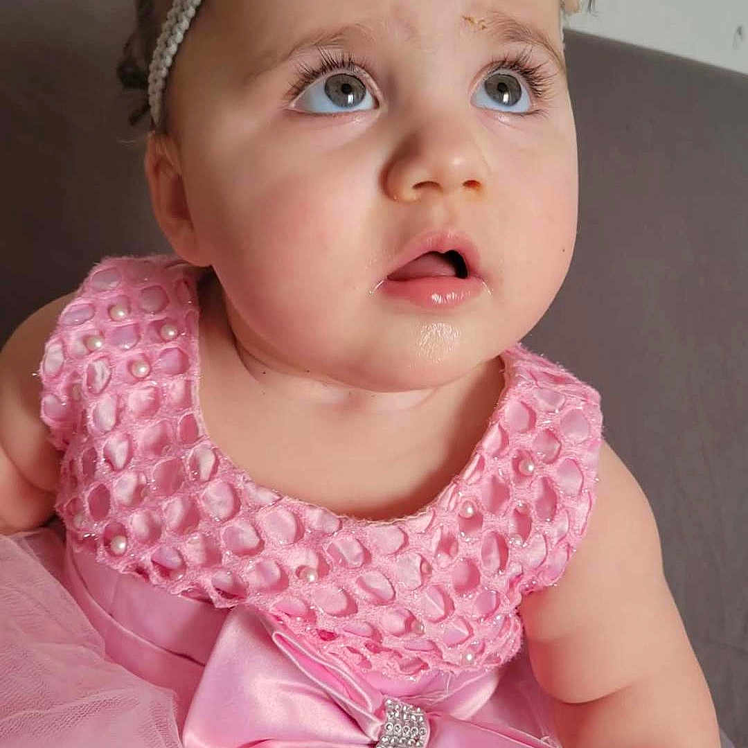 Emma Ridajova is registered to the contest to win money with this photo: adorable, baby, bow, child, closeup, curious, cute, expression, eyelashes, face, fashion, headband, indoor, person, pigtails, pink_dress, portrait, sitting, tulle, young_child