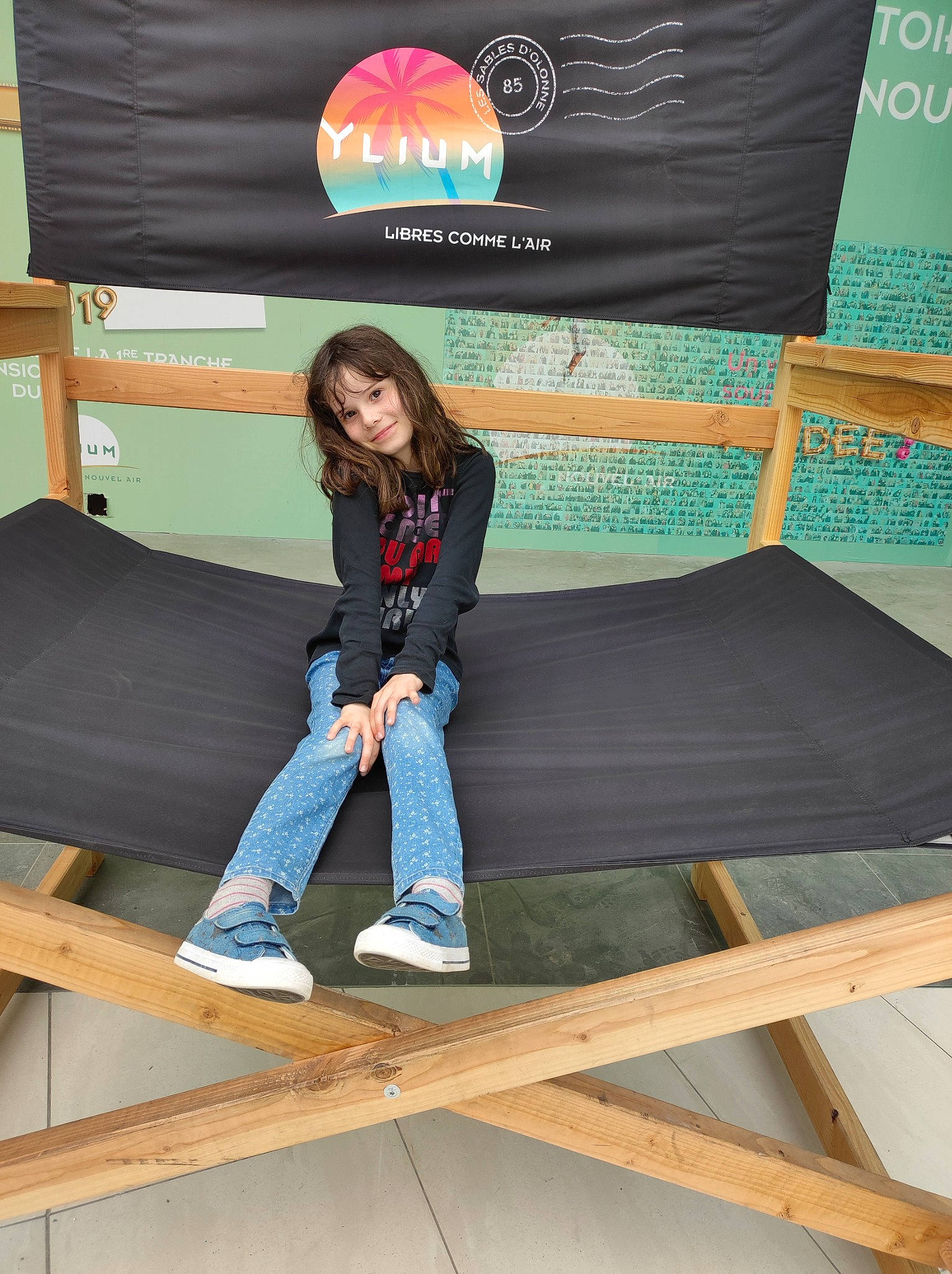 Solyne participe au concours pour gagner de l'argent avec cette photo : advertising, comfort, couch, denim, electric_blue, font, fun, jeans, joy, leisure, logo, pattern, person, recreation, room, sitting, sleeve, t_shirt, wood