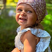 Eléa participe au concours pour gagner de l'argent avec cette photo : child, toddler, smiling, headscarf, outdoor, sunlight, portrait, happy, face, blue_eyes, floral_pattern, dress, nature, greenery, cute, skin, person, summer, closeup, young