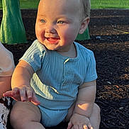Millie joined the competition — help win amazing prizes! baby, blue_onesie, child, cute, daytime, face, grass, hand, happy, head, infant, mulch, nature, outdoor, person, playground, sitting, skin, smiling, sunlight
