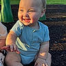 baby, blue_onesie, child, cute, daytime, face, grass, hand, happy, head, infant, mulch, nature, outdoor, person, playground, sitting, skin, smiling, sunlight