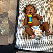 Sekani joined the competition — help win amazing prizes! baby, infant, diaper, rattle, playpen, mattress, zigzag_pattern, curly_hair, bare_chest, child, toy, floor_bed, cute, small_feet, indoors, mesh_sides, baby_toy, lying_down, young_child, playtime