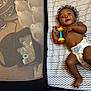 Sekani joined the competition — help win amazing prizes! baby, infant, diaper, toy, playpen, mesh, mattress, pattern, curly_hair, indoor, child, lying_down, smiling, cute, floor, colorful_toy, small_child, baby_toy, happy, play_area