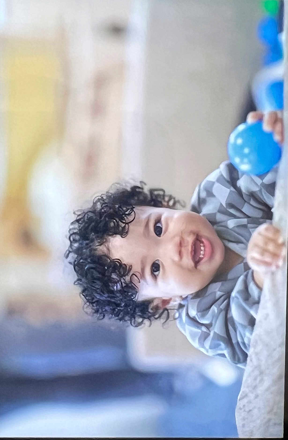 Junaid joined the competition — help win amazing prizes! child, toddler, curly_hair, smiling, blue_ball, indoor, person, happy, face, clothing, playful, portrait, closeup, baby, cute, hands, expression, young, leisure, fun