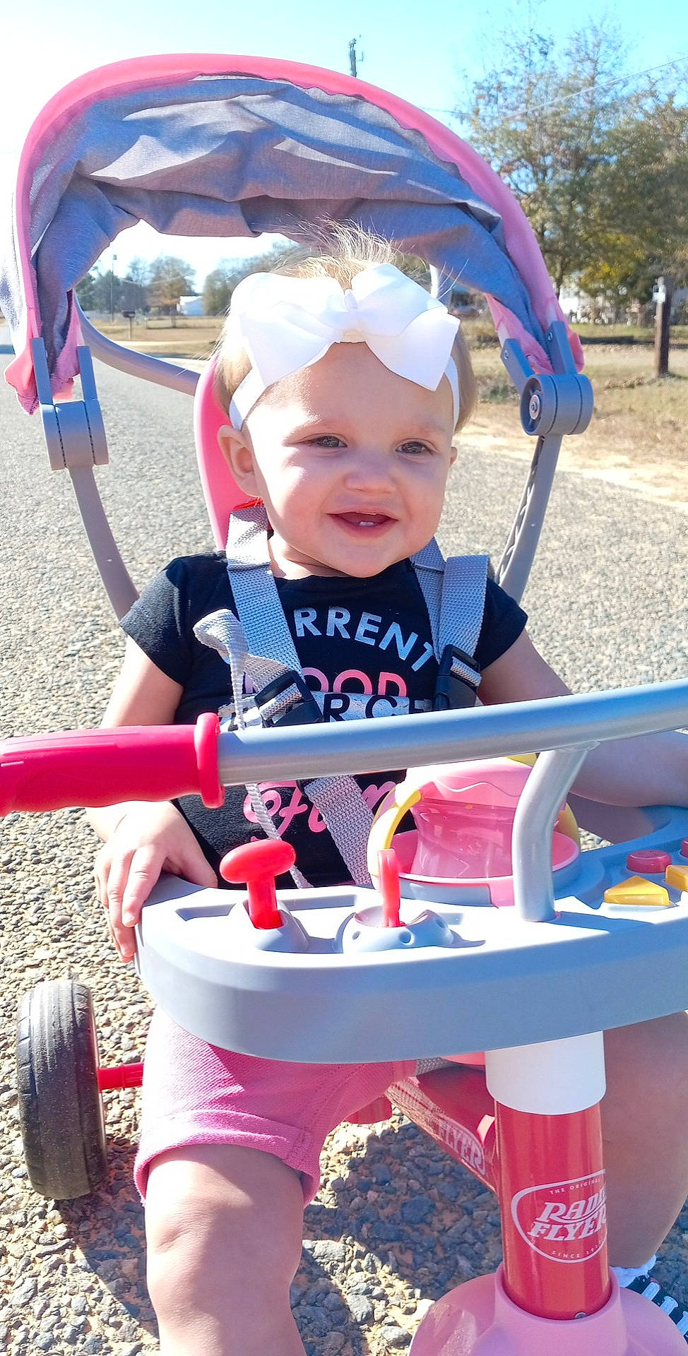 Madalynn is registered to the contest to win money with this photo: baby, baby_toddler_clothing, blue, child, fun, grass, happy, headwear, leisure, light, person, photograph, pink, product, recreation, red, riding_toy, smile, tire, toddler