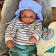 Raayan participe au concours pour gagner de l'argent avec cette photo : baby, child, cap, striped_shirt, green_pants, mirror, plush_toy, blanket, indoor, face, portrait, smiling, hand, furniture, floor, reflection, cute, relaxed, person, cozy