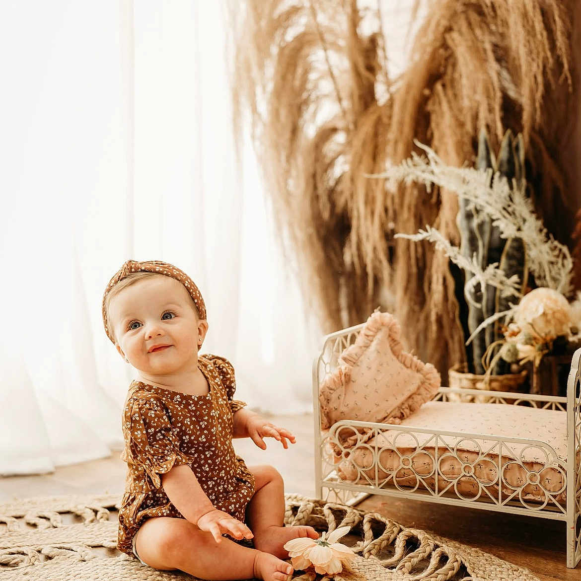 Aniston is registered to the contest to win money with this photo: baby, beachwear, blonde, clothing, cushion, doll, dress, face, furniture, hair, hat, head, homedecor, pants, person, photography, portrait, sitting, sleeve, toy