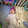Rayna is registered to the contest to win money with this photo: baby, smiling, crib, onesie, headband, toy, play_mat, numbers, star, child, infant, happy, face, indoor, patterned_clothing, colorful, soft_toys, baby_toys, sleepwear, toddler