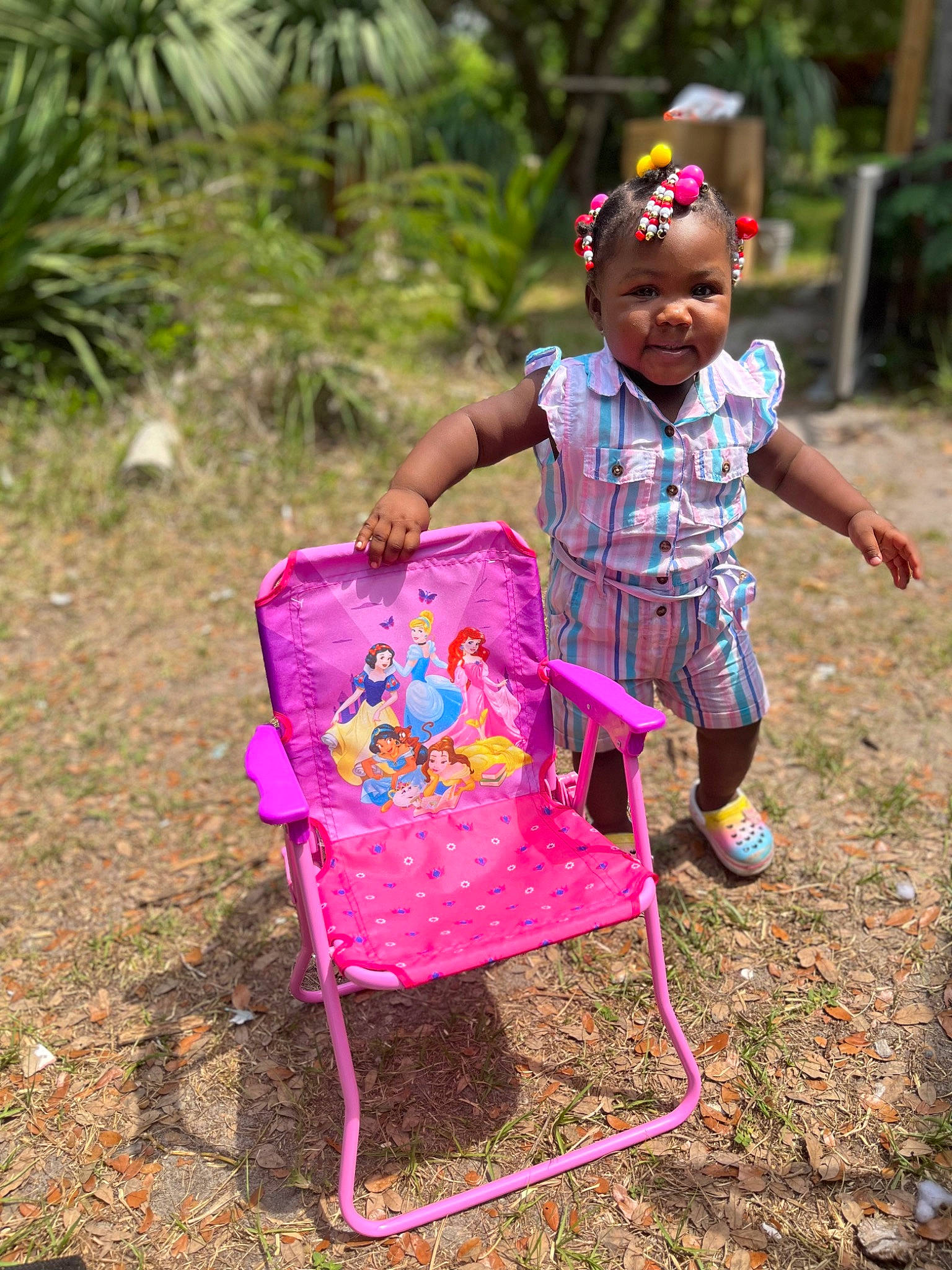 Zaleah joined the competition — help win amazing prizes! adaptation, baby_toddler_clothing, chair, child, dress, face, fun, grass, happy, leisure, magenta, people_in_nature, person, pink, plant, recreation, sandal, smile, soil, toddler