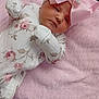 baby, newborn, infant, pink_bow, floral_onesie, blanket, embroidered_text, soft_texture, resting, cute, sleepy, indoor, child, portrait, headband, pink, white, cozy, peaceful, baby_clothes