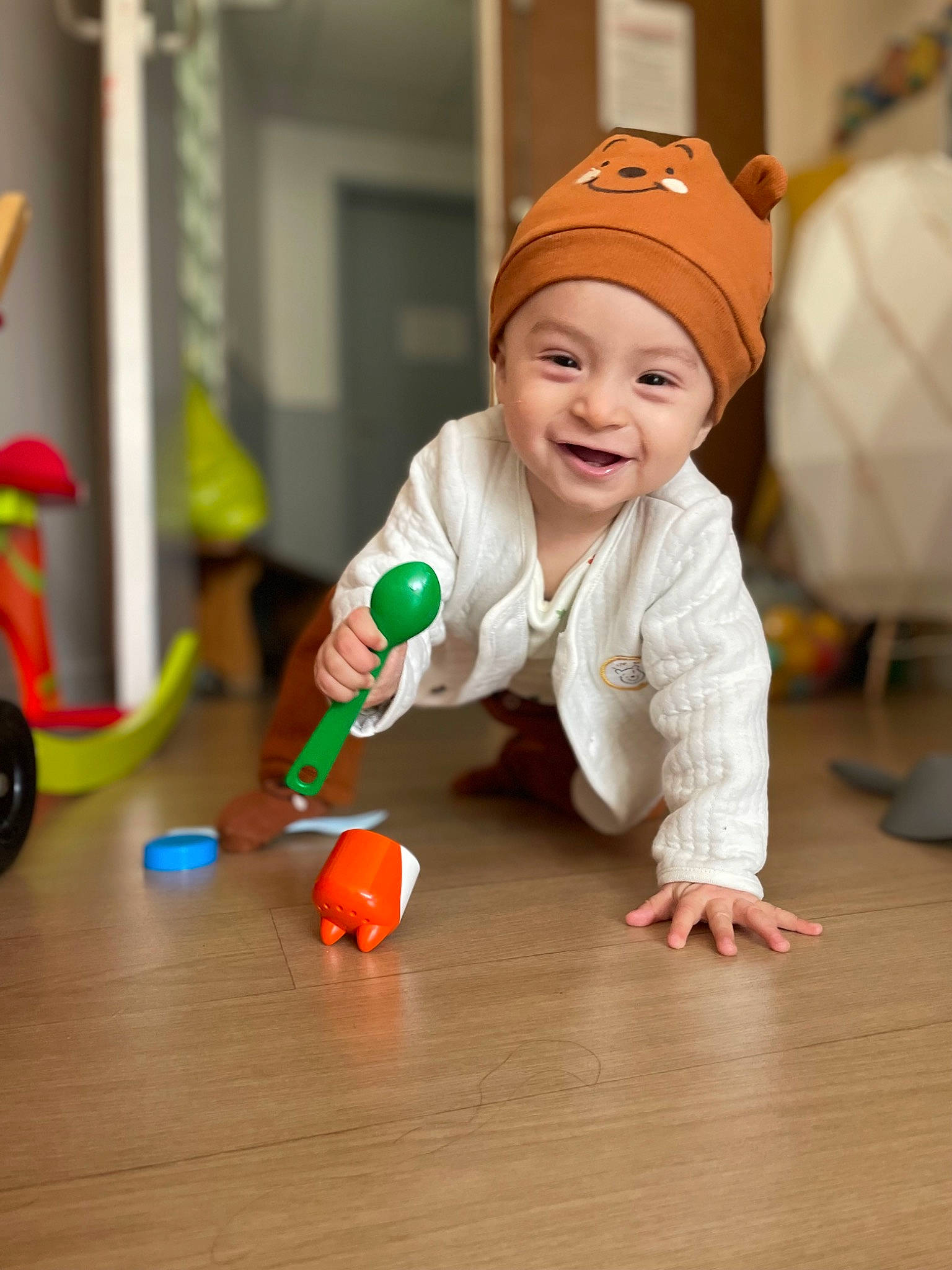 Maylone participe au concours pour gagner de l'argent avec cette photo : baby, baby_playing_with_toys, baby_toddler_clothing, cap, child, floor, flooring, fun, happy, hardwood, headwear, joy, orange, person, play, room, sitting, smile, toddler, toy