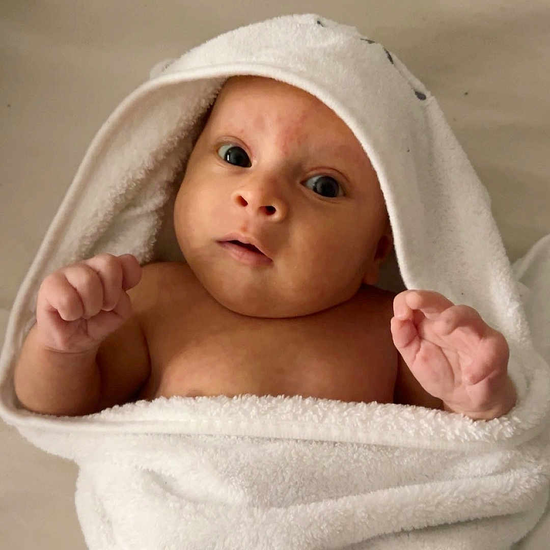 Waylon joined the competition — help win amazing prizes! baby, infant, towel, white_towel, hooded_towel, wrapped, skin, cute, expression, indoors, person, newborn, child, portrait, looking_up, hand, face, eyes, soft_texture, clean