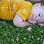baby, child, grass, flower_headband, yellow_shirt, bee_pattern, soccer_ball, clover, outdoor, nature, person, leg, shoe, playing, head, cute, resting, summer, casual, portrait