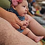Leonora is registered to the contest to win money with this photo: baby, child, infant, headband, flower, denim, clothing, hands, legs, person, adult, sitting, carpet, indoor, portrait, closeup, cute, holding, people, blurred_background