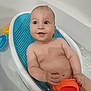 baby, bath, bathtub, water, child, smile, happy, toy, orange, blue, white, skin, face, hand, sitting, infant, cute, playful, relaxing, bathseat