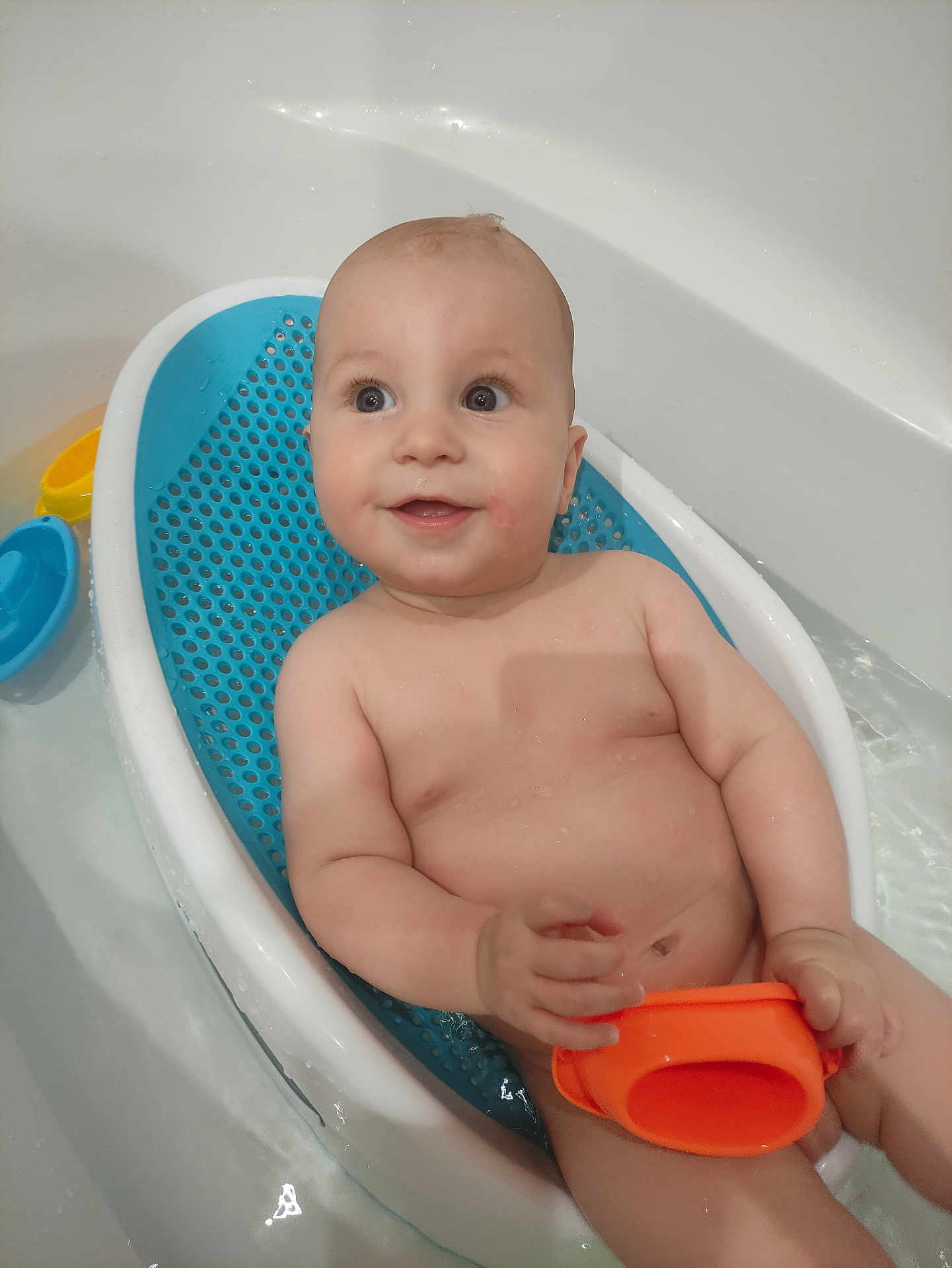 Fred participe au concours pour gagner de l'argent avec cette photo : baby, bath, bathtub, water, child, smile, happy, toy, orange, blue, white, skin, face, hand, sitting, infant, cute, playful, relaxing, bathseat