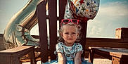 Willow is registered to the contest to win money with this photo: child, toddler, birthday, party_hat, balloon, blue_dress, barefoot, chair, wooden_furniture, outdoor, beach, sunny, celebration, happy, sunglasses, party, smiling, holiday, sky, festive