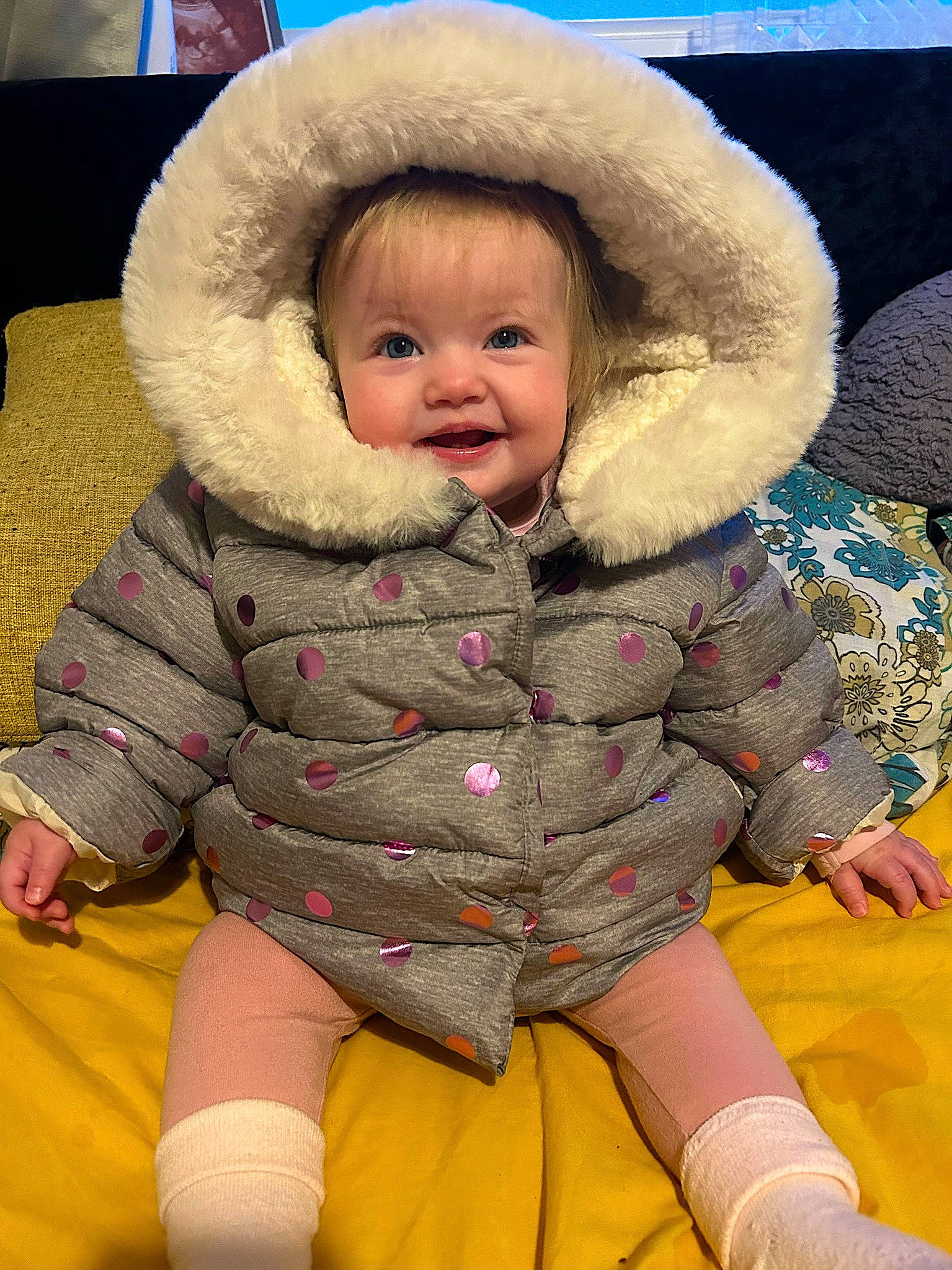 Maisie joined the competition — help win amazing prizes! baby, baby_toddler_clothing, cheek, child, comfort, flooring, fun, fur, fur_clothing, happy, hat, headgear, human_body, person, sitting, skin, sleeve, smile, thigh, toddler