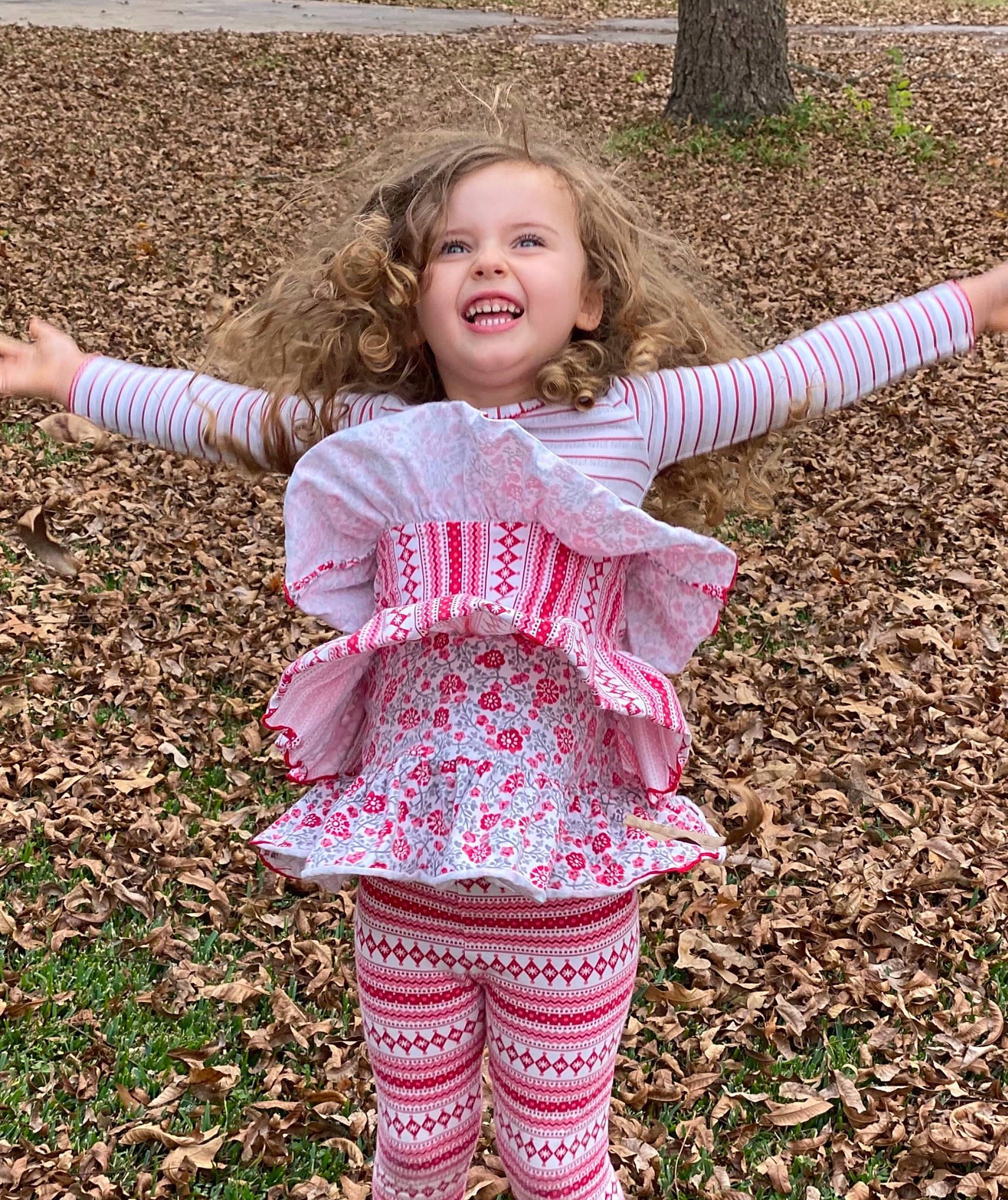 Amelia is registered to the contest to win money with this photo: baby_toddler_clothing, eye, face, fun, gesture, grass, grass_family, hair, happy, head, leaf, pattern, people_in_nature, person, pink, recreation, sleeve, smile, t_shirt, toddler