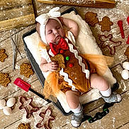 Kaisyn is registered to the contest to win money with this photo: baby, sleeping, gingerbread_costume, headband, baking_tray, flour, gingerbread_cookies, cookie_cutters, eggs, wooden_floor, whisk, spatula, tulle_skirt, sandals, socks, holiday_theme, cute, infant, kitchen, baking