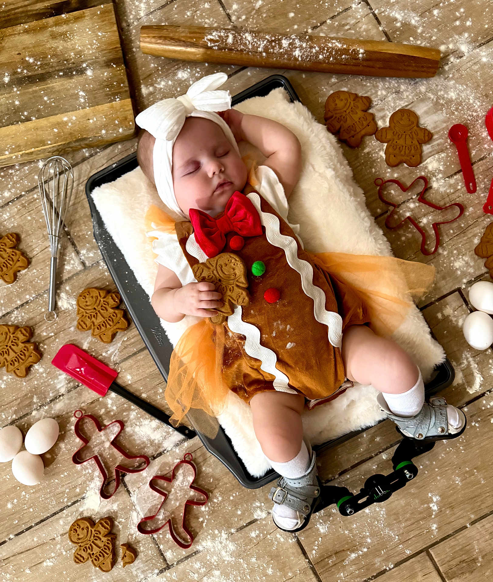 Kaisyn is registered to the contest to win money with this photo: baby, sleeping, gingerbread_costume, headband, baking_tray, flour, gingerbread_cookies, cookie_cutters, eggs, wooden_floor, whisk, spatula, tulle_skirt, sandals, socks, holiday_theme, cute, infant, kitchen, baking