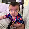 Giovani is registered to the contest to win money with this photo: baby, casual_clothing, child, comfort, couch, curious, cushion, expression, face, foot, furniture, hair, hand, indoors, living_room, pajamas, person, remote_control, seated, soft_texture