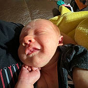Baylor joined the competition — help win amazing prizes! baby, sleeping, infant, hand, black_clothing, blanket, couch, household_items, pacifier, toy, remote_control, hairbrush, fabric, skin, face, arm, person, indoor, resting, cozy