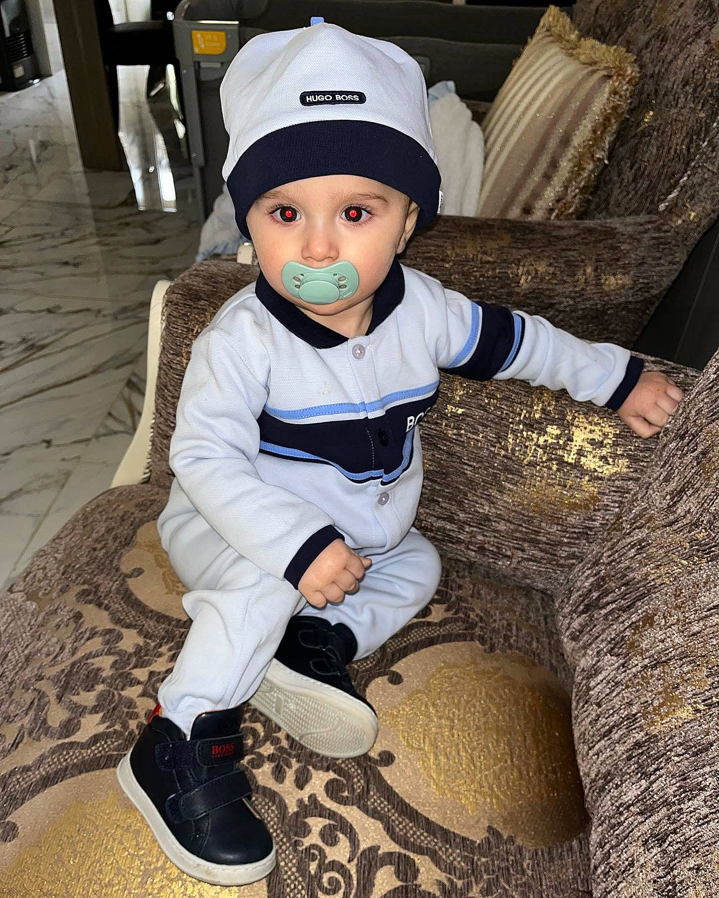 Boston participe au concours pour gagner de l'argent avec cette photo : baby, baby_toddler_clothing, cap, cool, costume_hat, electric_blue, fashion_accessory, flooring, footwear, fun, hat, headgear, headwear, human_leg, knee, person, personal_protective_equipment, sitting, sleeve, sneakers