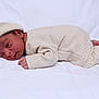 newborn, baby, infant, sleeping, hat, pajamas, quilted_clothing, white_background, soft_texture, lying_down, cute, small_hands, small_feet, peaceful, cozy, portrait, indoors, child, person, resting
