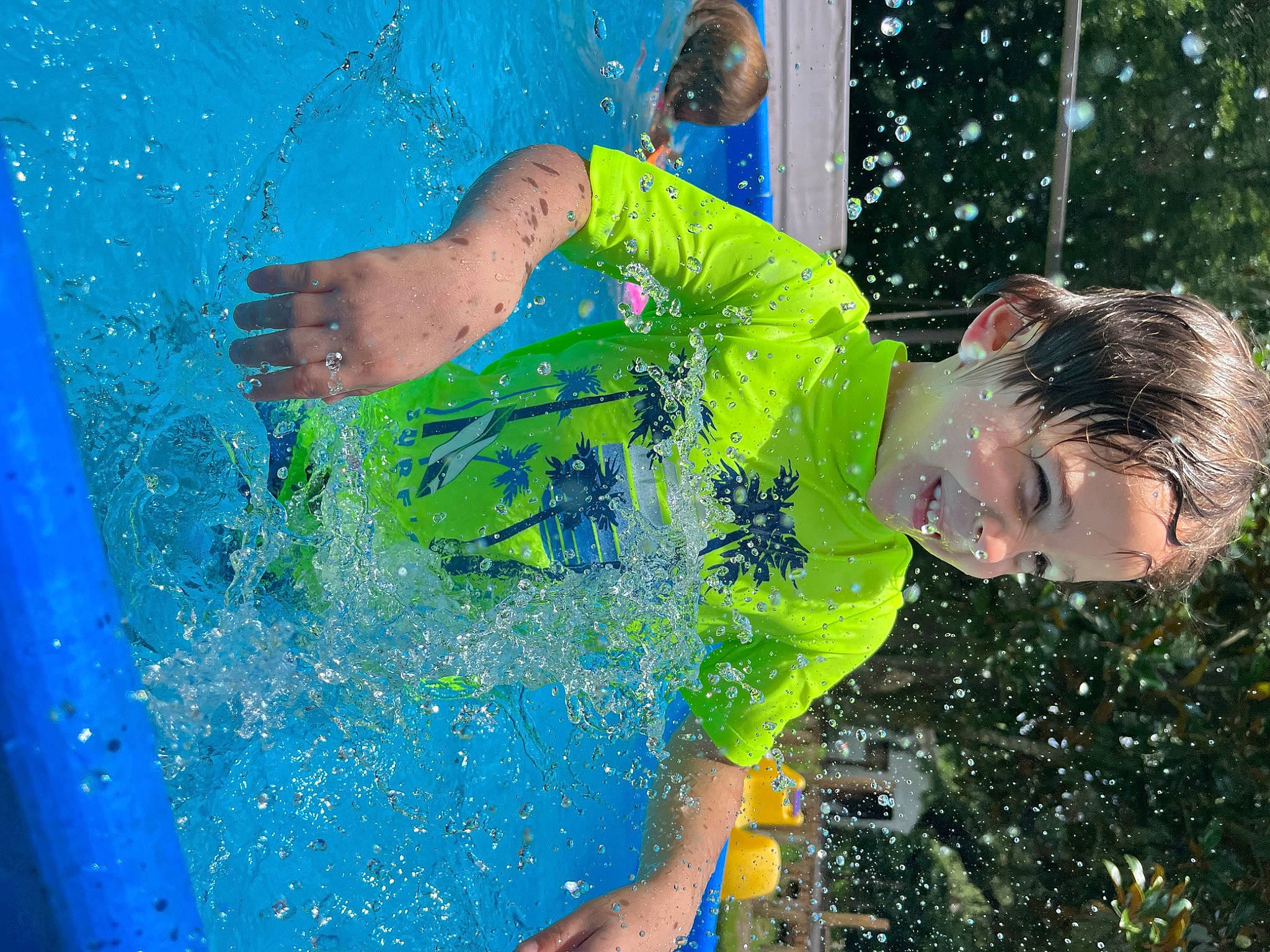 Dustin is registered to the contest to win money with this photo: arm, blue, child, fun, grass, hand, happy, leisure, liquid_bubble, paint, party_supply, people_in_nature, person, play, recreation, swimming_pool, t_shirt, toddler, vacation, water