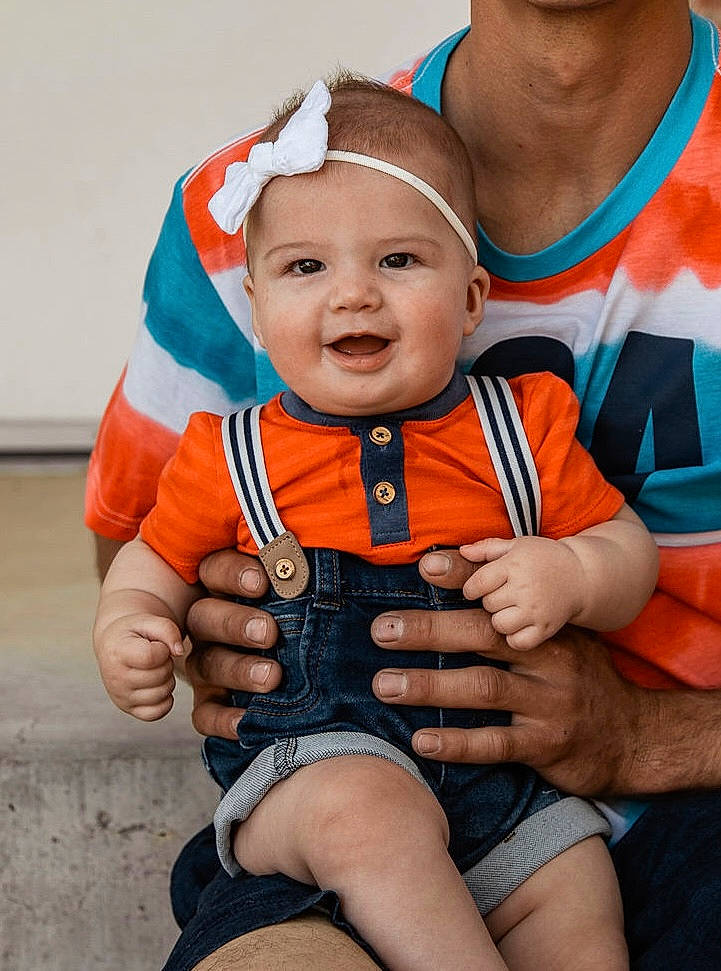 Scout joined the competition — help win amazing prizes! baby, baby_products, baby_toddler_clothing, child, event, face, finger, fun, gesture, glove, happy, head, headwear, human_body, orange, person, personal_protective_equipment, skin, sleeve, smile
