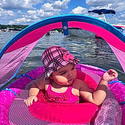 Chanel is registered to the contest to win money with this photo: baby, child, water, lake, float, pink, hat, swimsuit, sunny, outdoor, sky, clouds, boat, waterbottle, summer, relaxation, sunhat, infant, floating, recreation