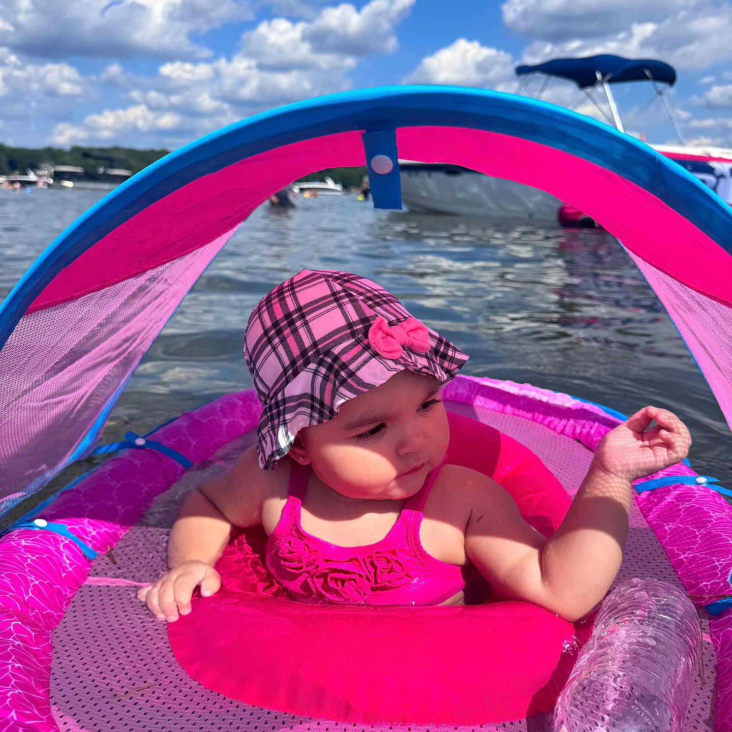 Chanel is registered to the contest to win money with this photo: baby, child, water, lake, float, pink, hat, swimsuit, sunny, outdoor, sky, clouds, boat, waterbottle, summer, relaxation, sunhat, infant, floating, recreation