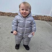 Cory joined the competition — help win amazing prizes! child, toddler, baby, smile, snowsuit, puffy_coat, hood, boots, standing, concrete, sidewalk, fence, outdoor, cold_weather, leaves, portrait, front_view, happy, candid, person