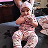 Hania joined the competition — help win amazing prizes! baby, child, pajamas, hat, mittens, tattoos, person, indoor, blanket, sitting, smiling, cute, family, cozy, home, furniture, television, supporting_hands, pink, purple