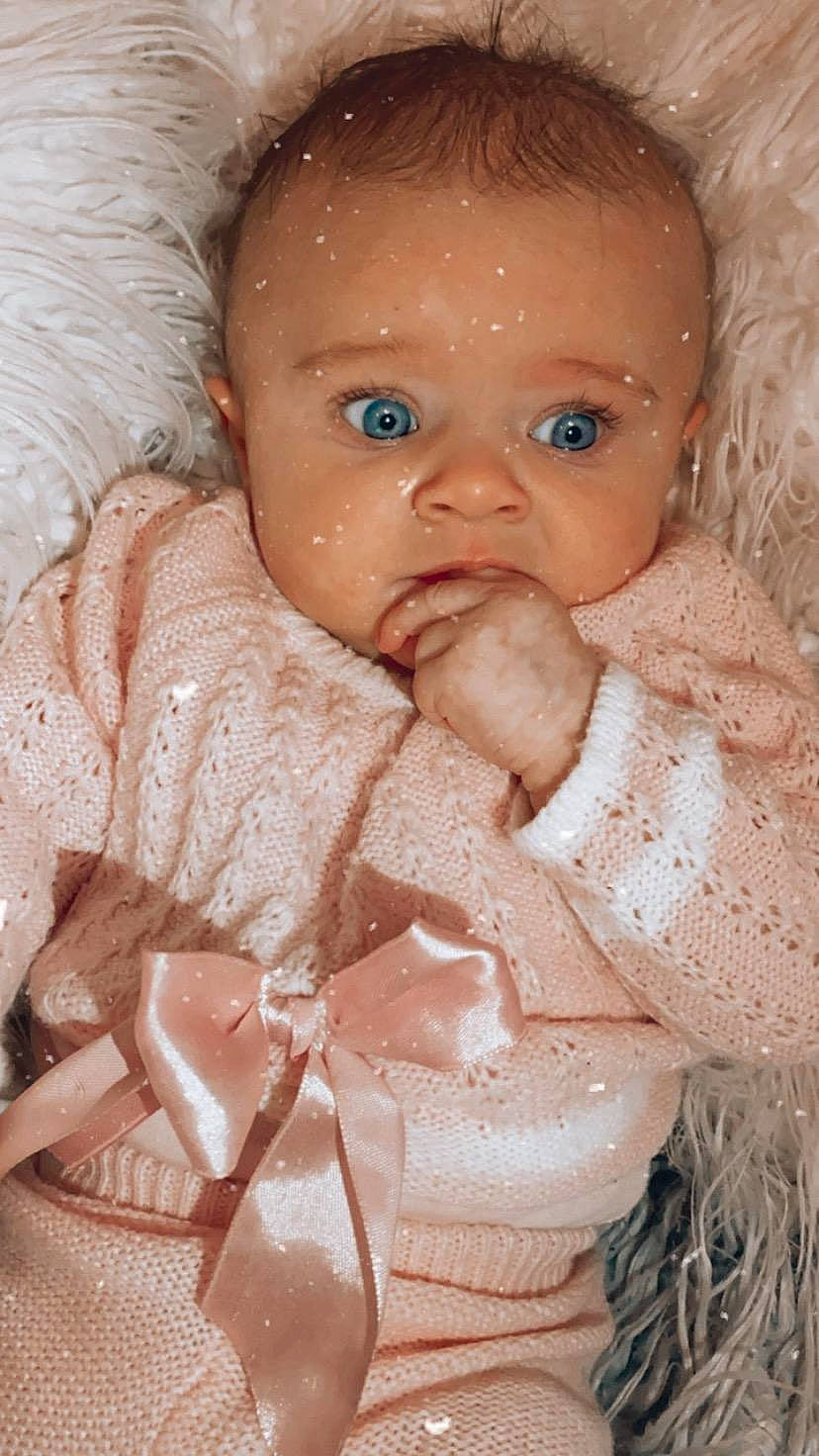 Lexie joined the competition — help win amazing prizes! arm, baby, baby_toddler_clothing, cheek, dress, eyelash, facial_expression, finger, hand, iris, lip, mouth, nail, neck, nose, person, pink, skin, sleeve, textile