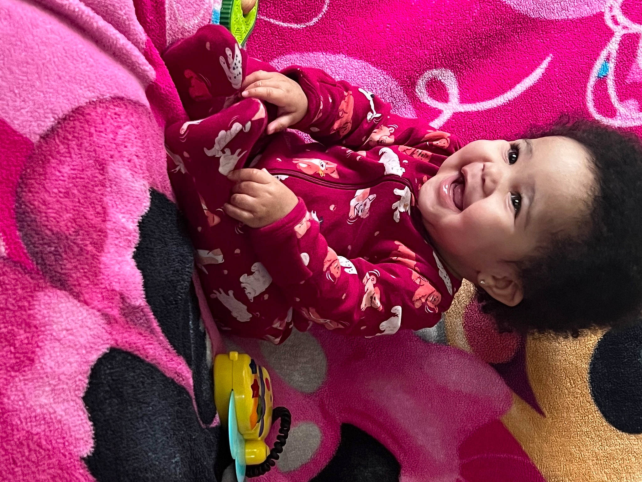 Khaleesi is registered to the contest to win money with this photo: baby, black_hair, child, cool, facial_expression, hairstyle, happy, human_body, lip, magenta, mouth, person, petal, pink, purple, red, skin, smile, textile, toddler