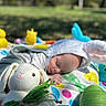 baby, bunny_ears, sleeping, blanket, outdoor, grass, toy, knitted_bunny, rubber_duck, colorful, cute, child, peaceful, easter, playful, infant, nature, soft, nap, spring