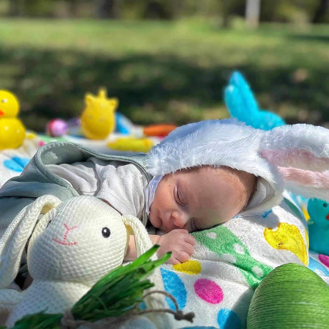 Levin joined the competition — help win amazing prizes! baby, bunny_ears, sleeping, blanket, outdoor, grass, toy, knitted_bunny, rubber_duck, colorful, cute, child, peaceful, easter, playful, infant, nature, soft, nap, spring