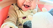 Luna is registered to the contest to win money with this photo: baby, child, infant, smiling, happy, portrait, face, eyes, blond_hair, plush_toy, stuffed_animal, playroom, indoor, seated, clothing, sweater, toy, colorful, close_up, joyful