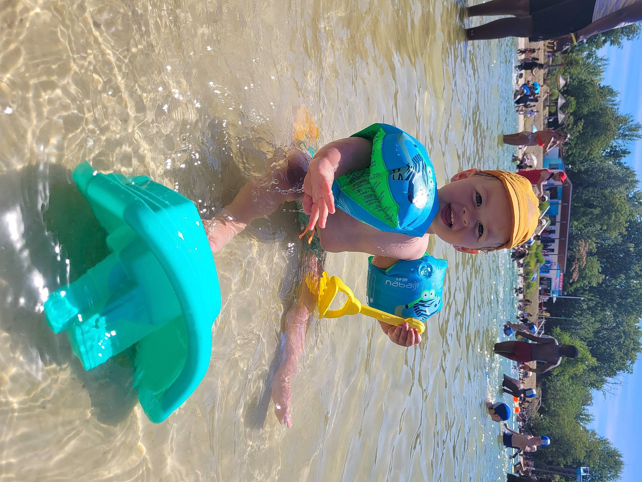 Noham a rejoint le concours — aidez-le/la à gagner de superbes lots ! aqua, azure, body_of_water, child, fun, happy, headgear, headwear, lake, leisure, person, personal_protective_equipment, play, recreation, sky, summer, swimwear, toddler, tree, vacation