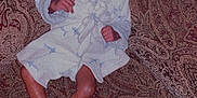 Skylan is registered to the contest to win money with this photo: baby, brown, child, clothing, couch, cute, expression, face, feet, furniture, home, indoor, infant, legs, pattern, person, portrait, robe, sitting, young