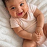 baby, blanket, child, cozy, curly_hair, cute, cute_expression, face, happy, human, indoors, infant, lying_down, onesie, portrait, relaxed, skin, small_hands, smiling, soft_texture