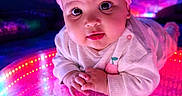 Atalia joined the competition — help win amazing prizes! baby, bright, child, colorful, curious, cute, face, glowing_surface, hands, headband, indoor, infant, led_lights, neon, pink_bow, portrait, reflection, soft_clothing, vibrant, wide_eyes
