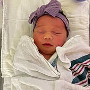 Francesca joined the competition — help win amazing prizes! newborn, baby, sleeping, wrapped, blanket, headband, purple, bow, peaceful, infant, swaddled, soft, cute, resting, towel, striped_blanket, indoors, closeup, person, child