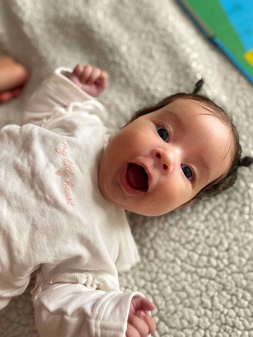 Maÿ-line a rejoint le concours — aidez-le/la à gagner de superbes lots ! baby, baby_toddler_clothing, cheek, child, chin, comfort, eye, face, flooring, fun, gesture, happy, iris, linens, nose, person, skin, sleeve, smile, surprise